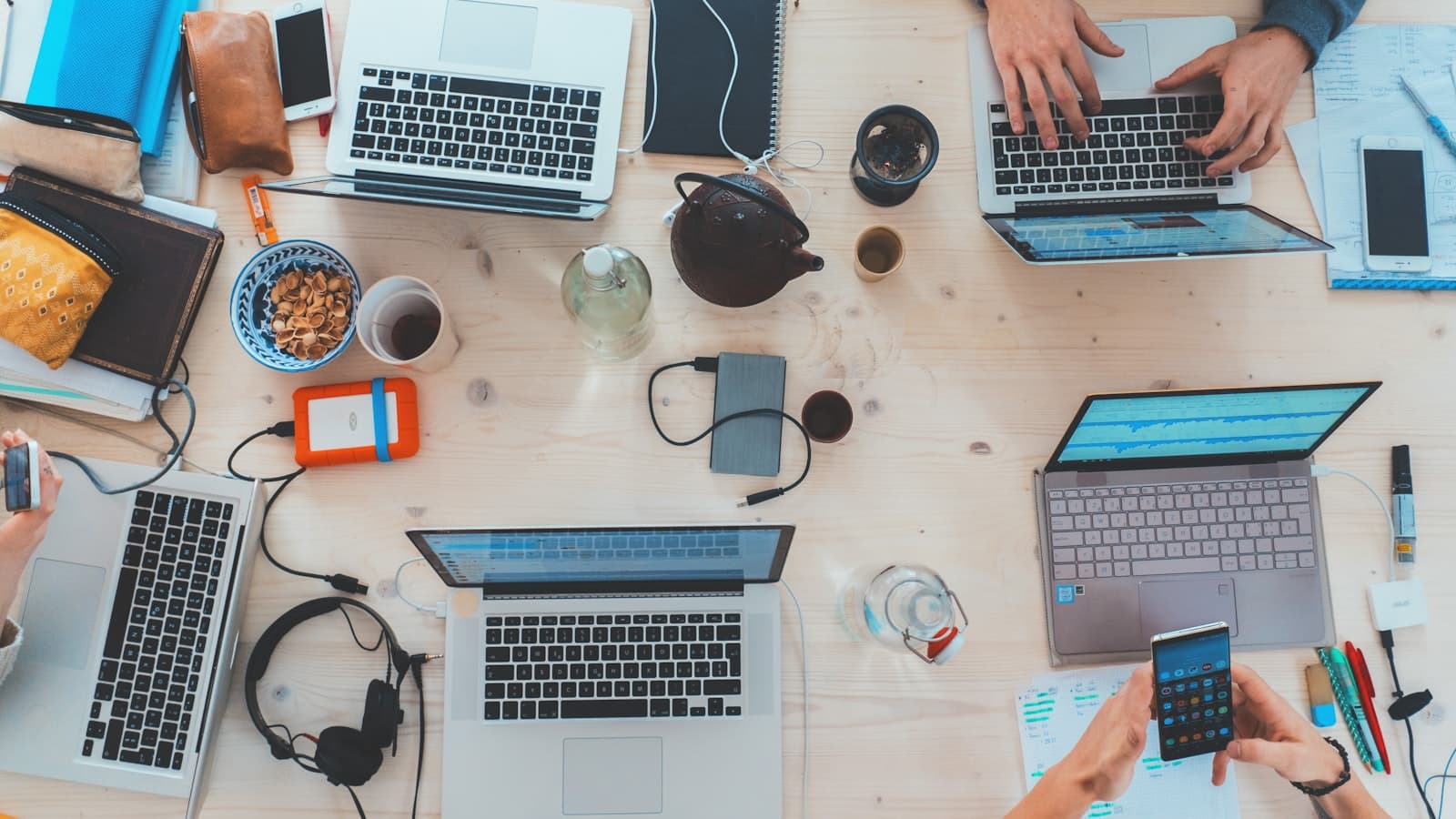 People collaborating at a table with laptops