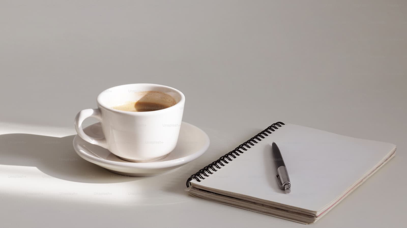 A cup of coffee and a notebook on a table