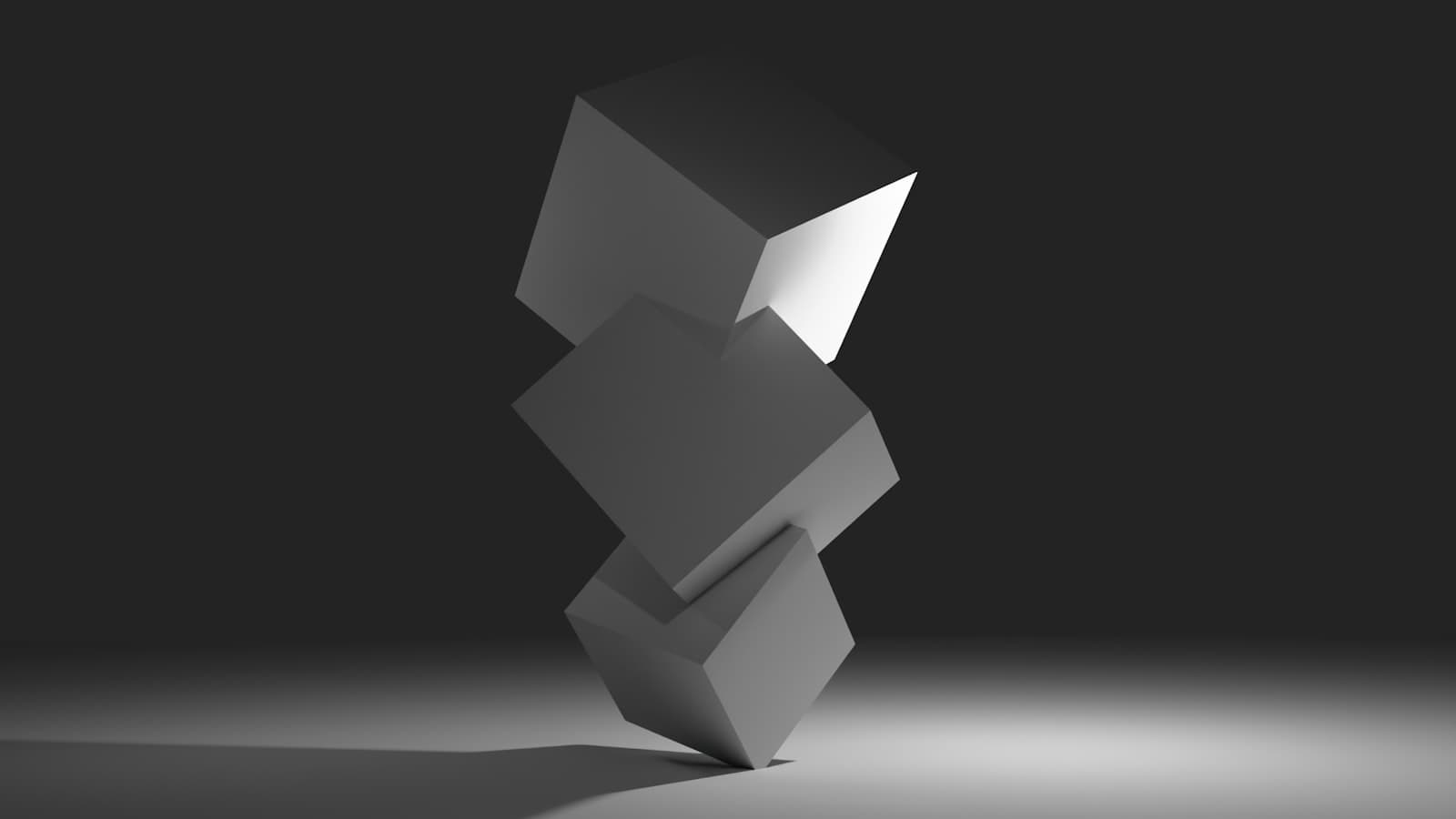 Stacked matte cubes balanced on a dark surface